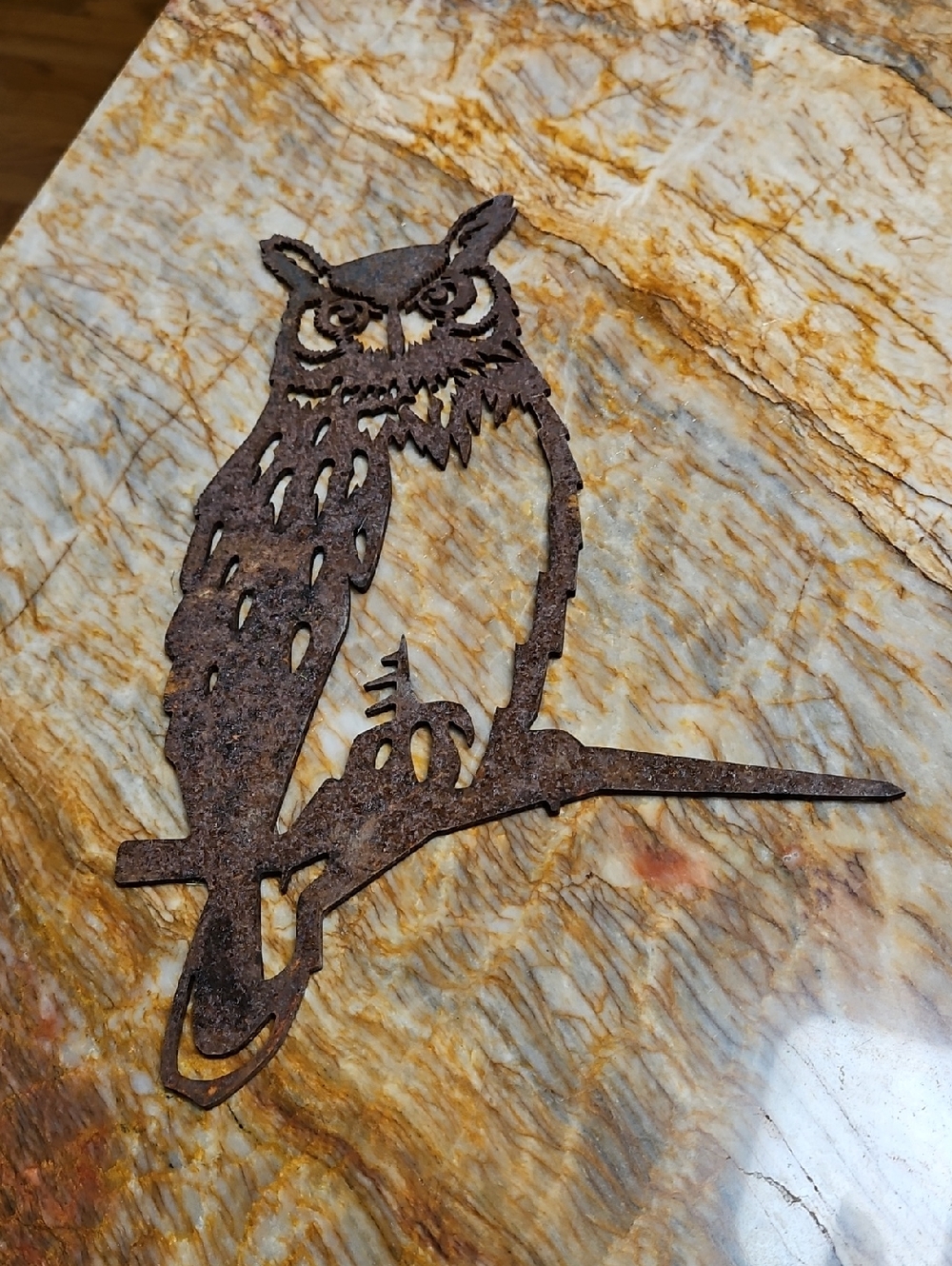 A rust-finished Great Horned Owl metal silhouette sculpture meant for outdoors.